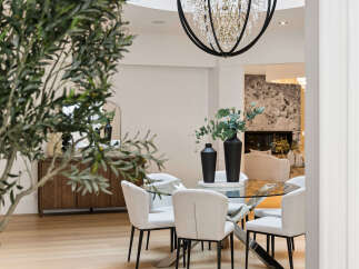 Experience elegant dining in this beautifully appointed space, featuring a sleek glass-top dining table with modern chairs.