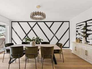 This elegant dining room features a striking geometric accent wall that adds a modern touch to the space.