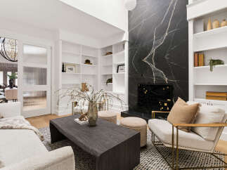 Experience modern luxury in this stunning living room, featuring a dramatic black marble fireplace and expansive built-in shelving.