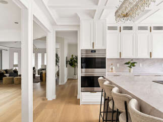 Experience luxury in this stunning kitchen featuring a sleek Wolf double oven and a beautiful marble island perfect for entertaining.