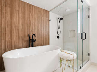 Experience modern luxury in this stunning bathroom, featuring a sleek freestanding bathtub and a spacious glass-enclosed shower.