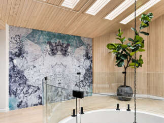Experience modern luxury in this stunning home featuring a unique marble-patterned accent wall and a sleek glass railing overlooking a circular staircase.