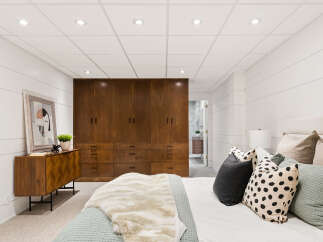 Discover this beautifully appointed bedroom featuring a spacious built-in wardrobe with rich wood finishes, perfect for ample storage.