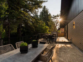 Enjoy outdoor living at its finest on this expansive deck, perfect for entertaining or relaxing amidst lush greenery.