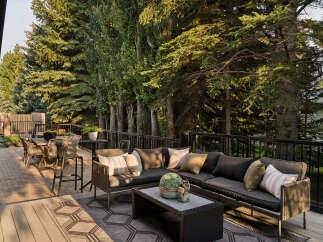 Enjoy outdoor living at its finest on this spacious deck, featuring a comfortable sectional sofa and a dining set perfect for al fresco meals.
