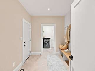 Step into this inviting entryway featuring a convenient laundry room accessible through a doorway.
