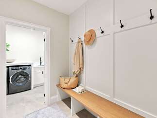 This inviting entryway features a convenient bench with a woven basket and a straw hat, perfect for a quick stop.