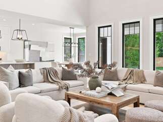 Experience modern living in this spacious great room, featuring a large sectional sofa perfect for gatherings and a rustic wooden coffee table as a centerpiece.