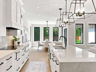 Experience modern luxury in this stunning kitchen, featuring sleek white cabinetry, elegant quartz countertops, and a spacious island with a deep sink.