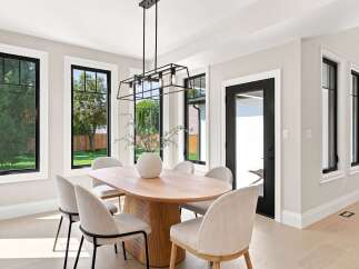 Experience modern elegance in this dining room, featuring a stunning oval wood table as the centerpiece, complemented by chic upholstered chairs.