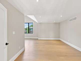 Step into this beautifully renovated room featuring a spacious open floor plan and elegant hardwood flooring.