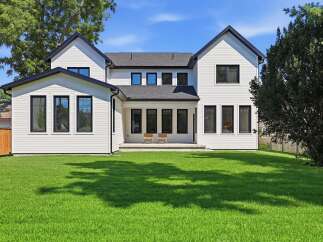 Discover this stunning modern farmhouse, featuring crisp white siding and a sleek black roofline.
