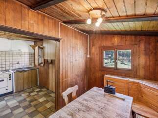 Step into this charming rustic kitchen, featuring warm wooden paneling throughout and a cozy dining area.