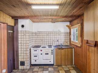 Discover a charming rustic kitchen featuring a classic white stove and a double basin sink, perfect for preparing meals.