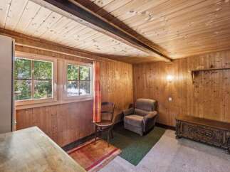 Step into this charming rustic room featuring warm wood-paneled walls and a cozy ceiling.