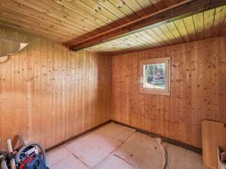 Discover this charming room featuring warm, natural wood paneling on the walls and ceiling, creating a cozy and rustic ambiance.