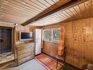 This charming rustic room features warm wood paneling throughout, creating a cozy and inviting atmosphere.