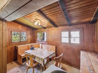 Step into this charming rustic dining area, featuring warm wooden paneling and exposed beams for an authentic cabin feel.
