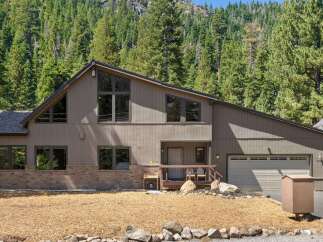 Nestled amidst a lush forest, this stunning home offers a serene mountain retreat.