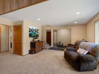 Step into this inviting living space featuring plush carpeting and a cozy recliner, perfect for relaxing evenings.
