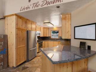 This charming kitchen boasts beautiful natural wood cabinetry and a spacious granite countertop, perfect for meal preparation and entertaining.