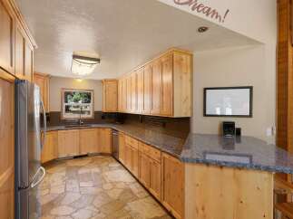 Discover this charming kitchen featuring custom light wood cabinetry and elegant granite countertops.