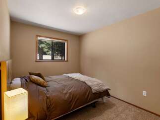 This cozy bedroom features a comfortable queen-size bed with plush brown bedding and decorative pillows.