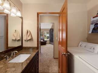 This spacious bathroom features a granite-topped vanity with a modern sink and ample storage.
