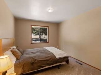 This cozy bedroom features a comfortable queen-size bed with plush brown bedding and decorative pillows.