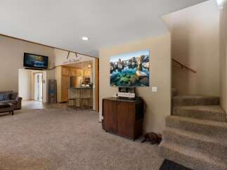 Step into this inviting living space featuring a cozy sectional sofa and a large flat-screen TV, perfect for relaxation and entertainment.