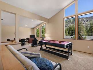 Experience breathtaking mountain views from this spacious game room, featuring a professional pool table and ample space for entertainment.