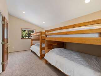 This charming bedroom features two sets of sturdy wooden bunk beds, perfect for accommodating family and friends.