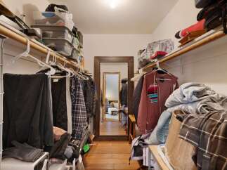 Discover ample storage in this spacious walk-in closet, featuring extensive shelving and hanging rods to keep your wardrobe organized.