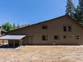 Discover this spacious property featuring a large, brown-sided building with a covered carport.