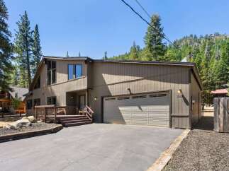 Nestled amidst towering pine trees and a scenic mountain backdrop, this charming property offers a serene retreat.