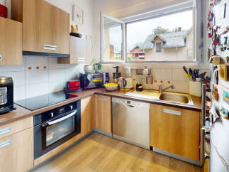 This modern kitchen features sleek wooden cabinetry and a convenient built-in oven and stovetop.