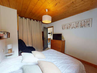 This cozy bedroom features a comfortable bed with crisp white linens and plush pillows, perfect for a restful night's sleep.