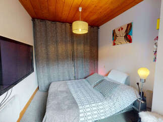 This cozy bedroom features a comfortable bed with stylish patterned pillows, perfect for a relaxing retreat.