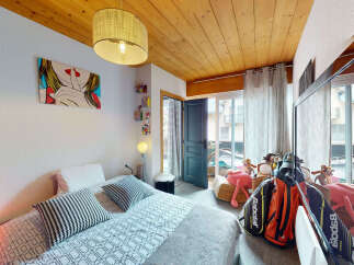 This charming bedroom features a stylish pop art print and a cozy bed with patterned pillows, perfect for relaxation.