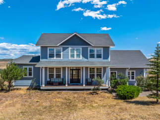 Discover this stunning blue two-story home nestled in a picturesque landscape.