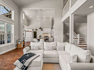 Experience luxury living in this spacious open-concept home, featuring a stunning vaulted ceiling and abundant natural light from large windows.