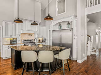 Experience luxury in this stunning kitchen featuring a large granite island with seating, perfect for entertaining.