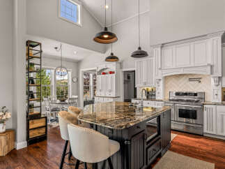 Experience the epitome of modern living in this stunning kitchen, featuring a spacious island with granite countertops and comfortable seating.