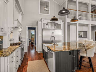 Experience luxury in this stunning kitchen featuring a large island with granite countertops and a farmhouse sink, perfect for entertaining.