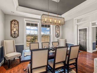 Experience elegant dining in this beautifully appointed room, featuring a dark wood table and upholstered chairs perfect for hosting.