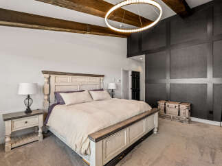 Experience luxury in this master suite, featuring a grand king-sized bed with plush bedding and elegant nightstands.