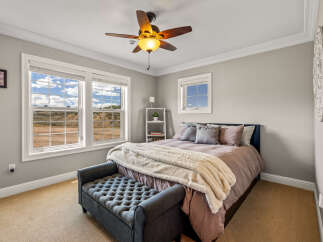 Experience comfort and style in this inviting bedroom, featuring a plush tufted bench at the foot of the bed and a luxurious faux fur throw.