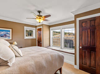 Experience serene country living in this charming bedroom, featuring a cozy bed adorned with plush pillows and a textured throw.