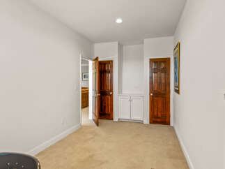 Discover this charming hallway featuring two elegant wooden doors and a built-in white cabinet, perfect for storage.