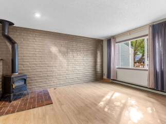 Cozy living room featuring a rustic brick accent wall and a modern wood-burning stove, perfect for chilly evenings.
